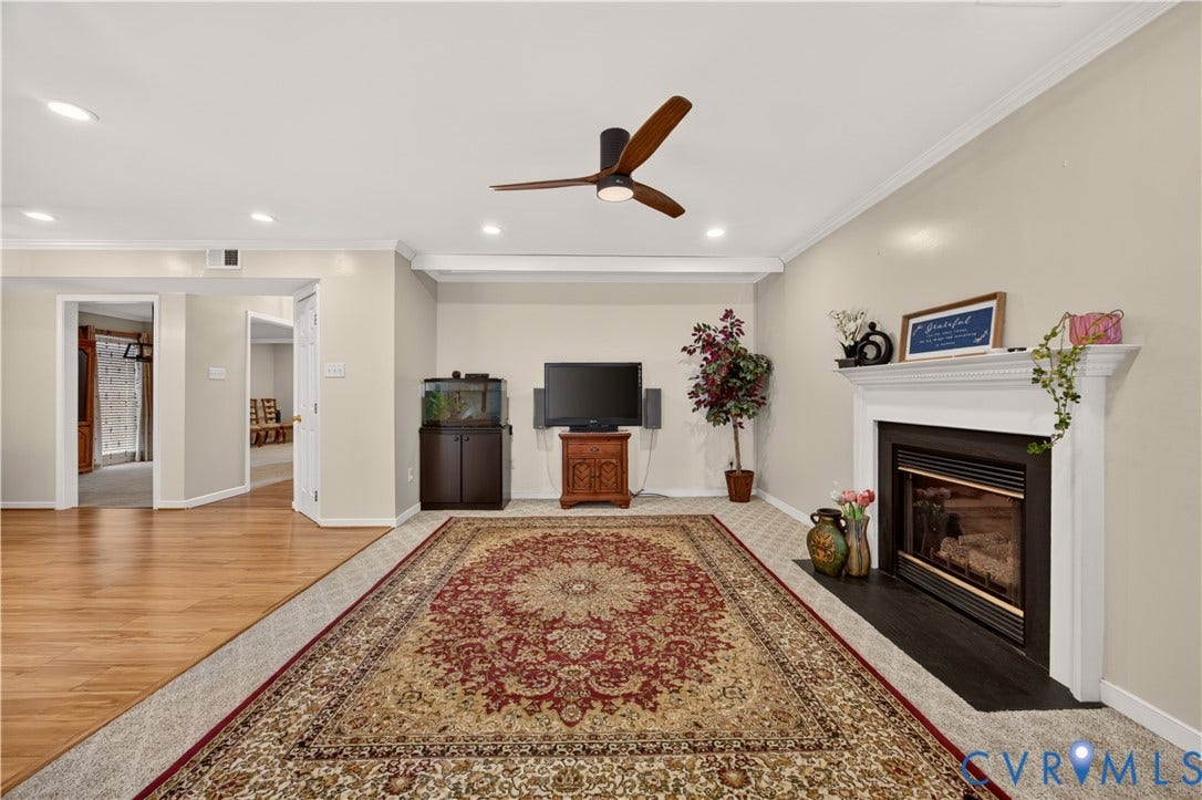 9516 Hungary Woods Drive, Henrico, VA 23060 Recessed lighting, crown molding, a ceiling fan, a fireplace with a white mantel, and wood-finish flooring