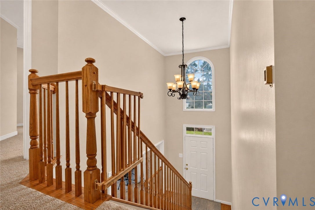 9516 Hungary Woods Drive, Henrico, VA 23060 Two-story entryway featuring a decorative chandelier, arched window, and wood stair railing