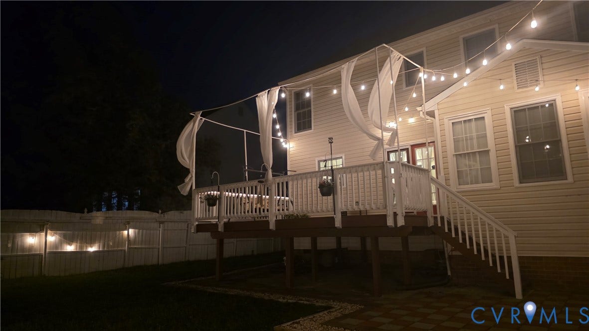 9516 Hungary Woods Drive, Henrico, VA 23060 Expansive elevated deck with white railings and staircase, paver patio, and fenced backyard with string lighting