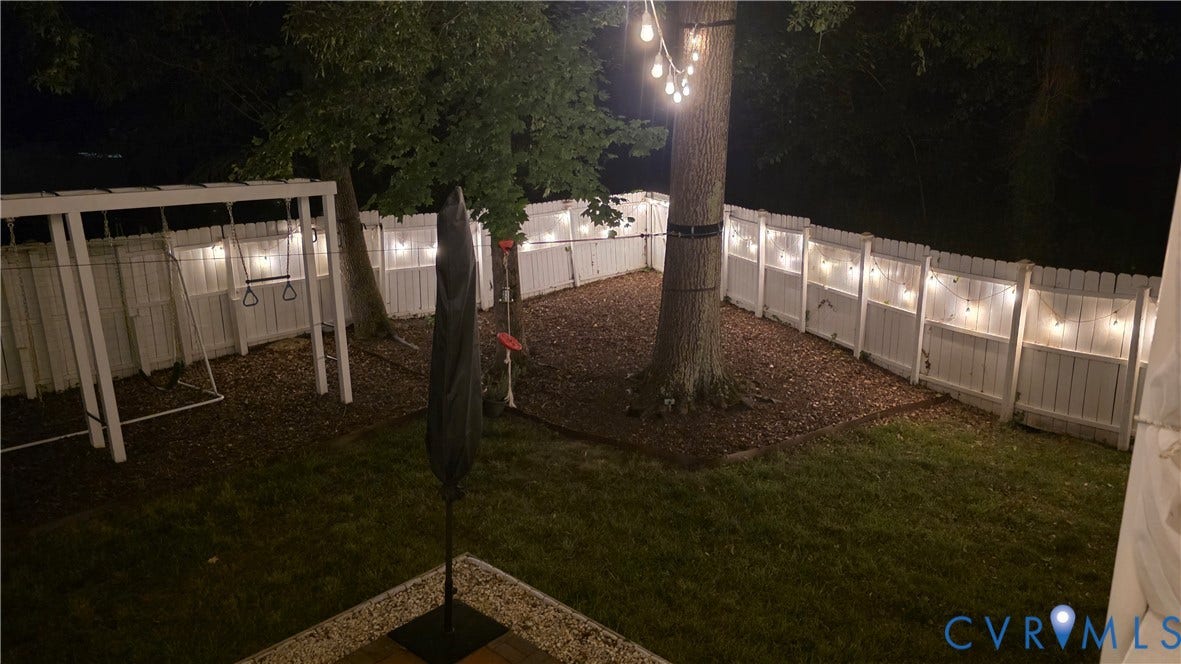 9516 Hungary Woods Drive, Henrico, VA 23060 Spacious backyard featuring a white privacy fence, and string lighting