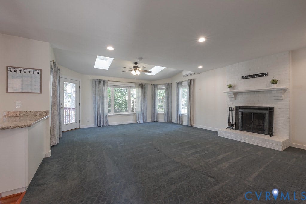 White brick fireplace with mantel, recessed lighting, skylights and mini split for extra HVAC comfort