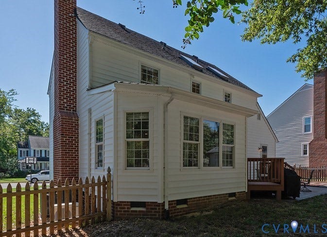 White siding exterior showing a brick chimney, and upper level skylights