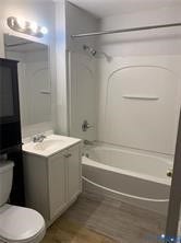 3119-A 4th Avenue, Richmond, VA 23222 Bathroom featuring a white vanity with a single basin sink, brushed nickel faucet, and wood-finish flooring