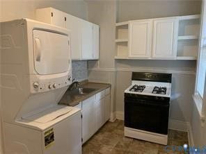3119-A 4th Avenue, Richmond, VA 23222 White stacked washer and dryer, white cabinetry with open shelving, gas range, and a single basin sink
