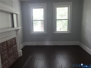3119-B 4th Avenue, Richmond, VA 23222 Hardwood flooring with a dark finish, two double-hung windows, white trim, and a white fireplace mantel with decorative detailing