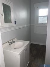 3119-B 4th Avenue, Richmond, VA 23222 White vanity with integrated sink, chrome faucet, window with white trim, and wood-finish flooring