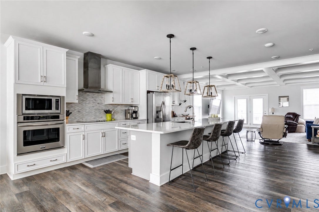 2 Flatwater Row, #B, Rocketts Landing, Henrico, VA 23231 Modern kitchen featuring white cabinetry, integrated stainless steel appliances, a center island with pendant lighting, and wood-finish flooring
