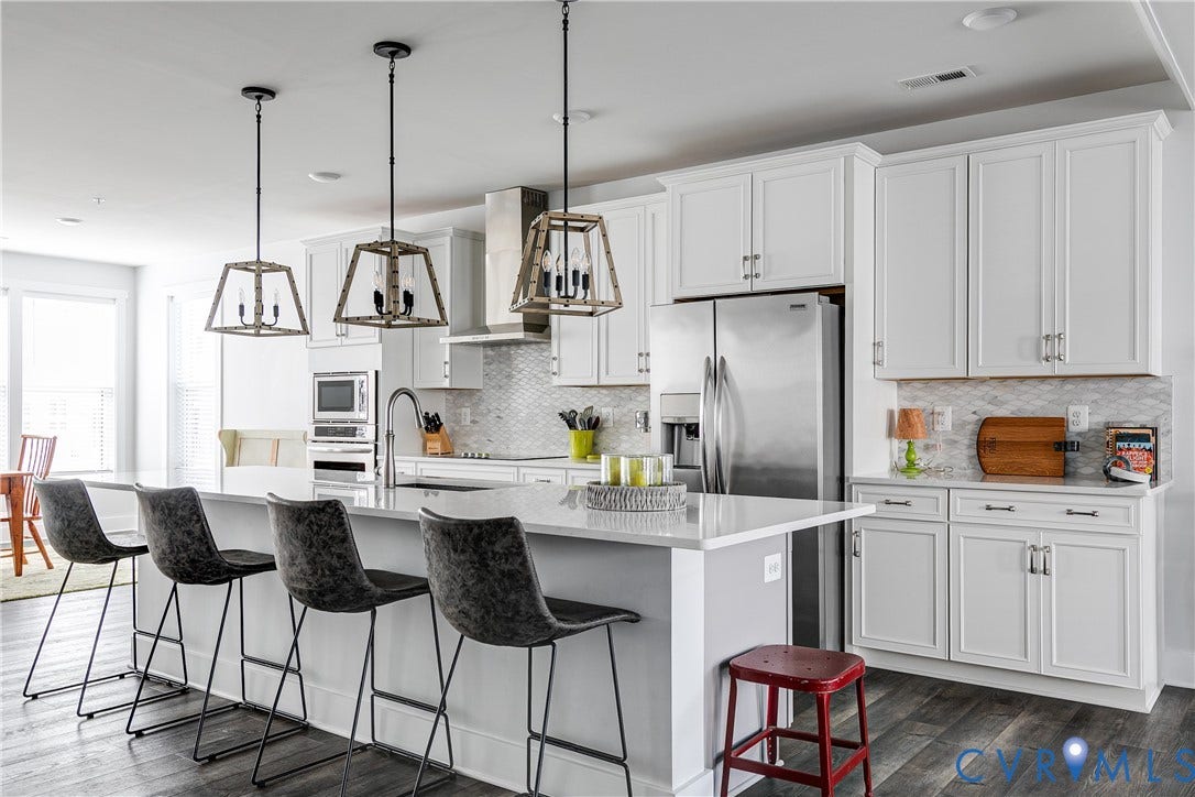 2 Flatwater Row, #B, Rocketts Landing, Henrico, VA 23231 Kitchen featuring an island with a light-colored countertop, white cabinetry with silver-toned hardware, stainless steel appliances, and wood-finish flooring