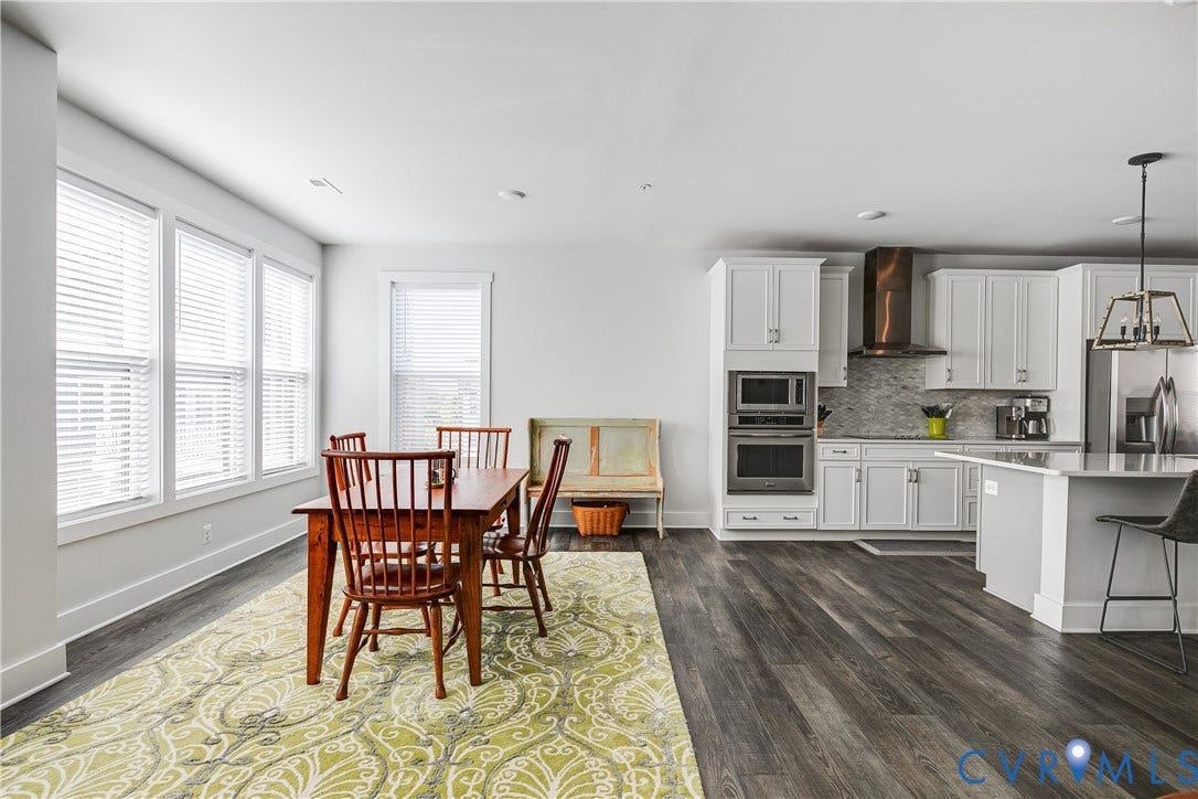 2 Flatwater Row, #B, Rocketts Landing, Henrico, VA 23231 White shaker cabinetry, stainless steel appliances, wood-finish flooring, recessed lighting, and a kitchen island with seating