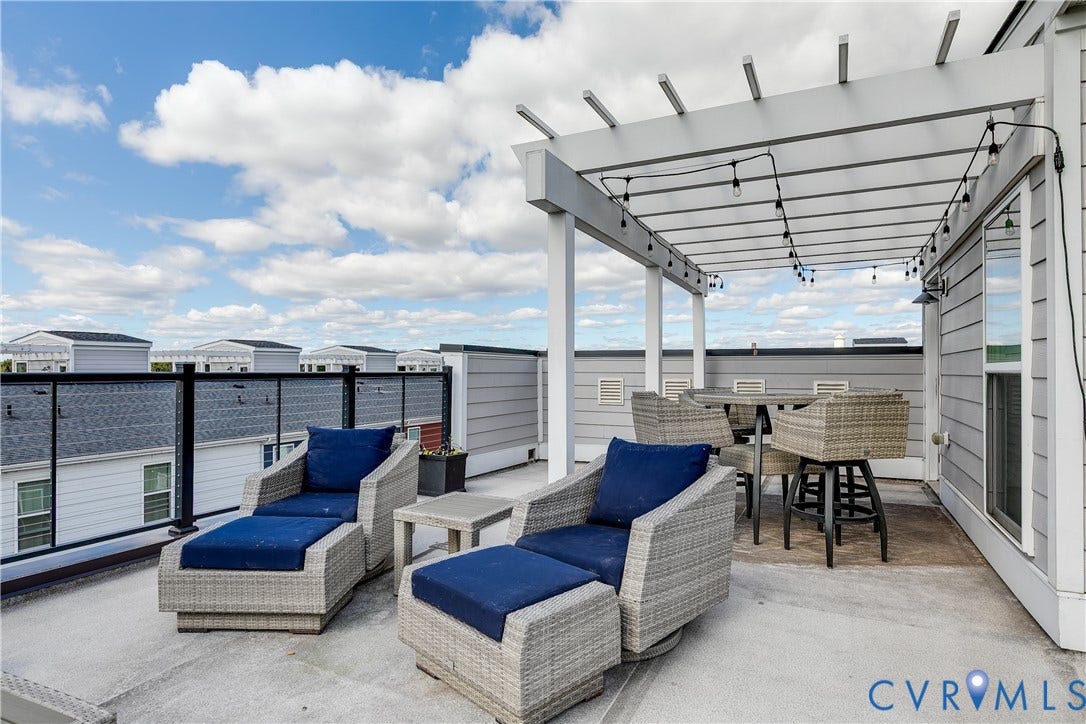 2 Flatwater Row, #B, Rocketts Landing, Henrico, VA 23231 Expansive rooftop deck featuring a white pergola, dark-framed railings, and durable concrete surfacing