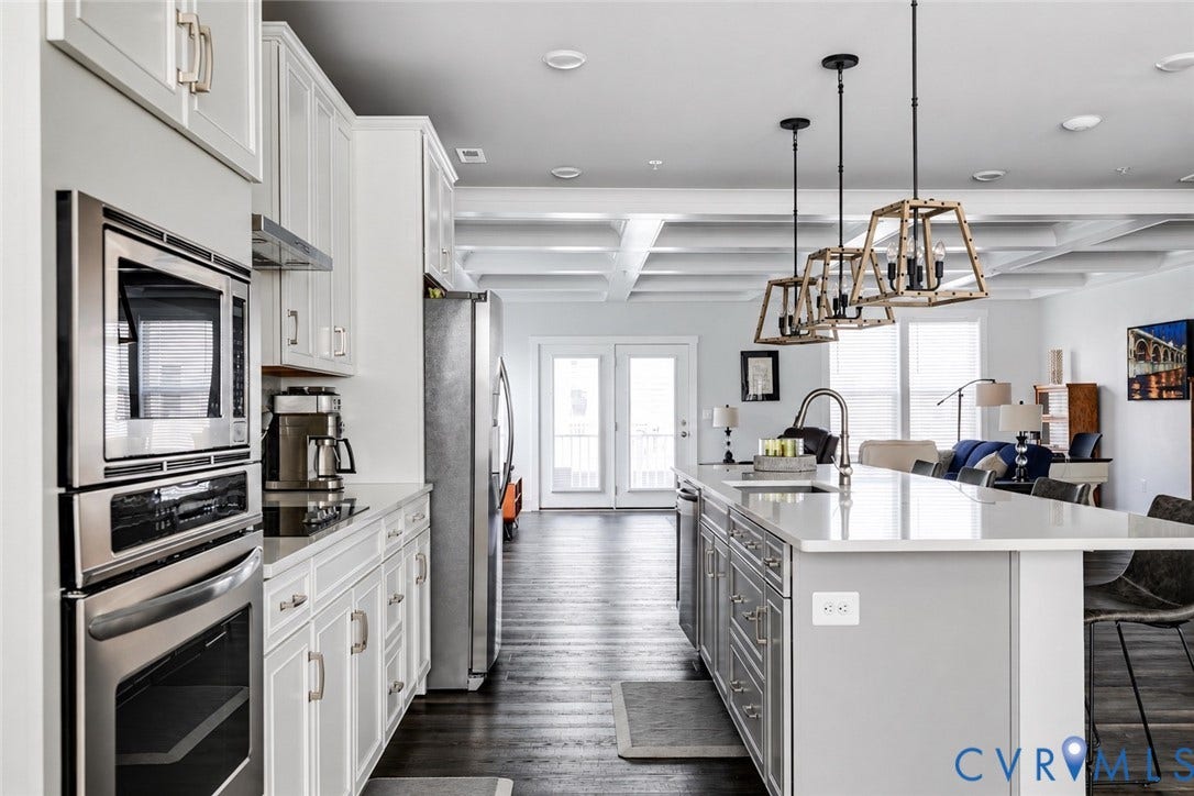 2 Flatwater Row, #B, Rocketts Landing, Henrico, VA 23231 Kitchen featuring a large island, stainless steel appliances, white cabinetry, and dark wood-finish flooring