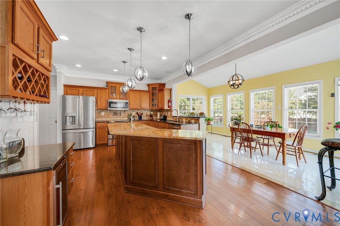 10808 Pruett Lane, Henrico, VA 23059 Kitchen featuring wood cabinetry, stainless steel appliances, a center island with a stone-finish countertop, and wood-finish flooring