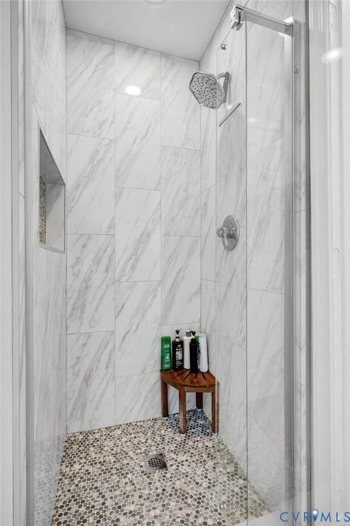 10808 Pruett Lane, Henrico, VA 23059 Walk-in shower with full-height wall tiling, pebble-finish floor, and a built-in shower niche