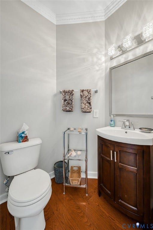 10808 Pruett Lane, Henrico, VA 23059 Wood-finish flooring with a white toilet, dark wood-finish vanity with an integrated sink, and an ornamental light fixture