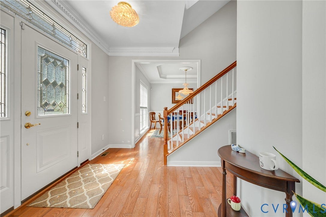 10808 Pruett Lane, Henrico, VA 23059 Entryway featuring wood-finish flooring, a white front door with decorative glass, and a staircase with white spindles and a wood handrail