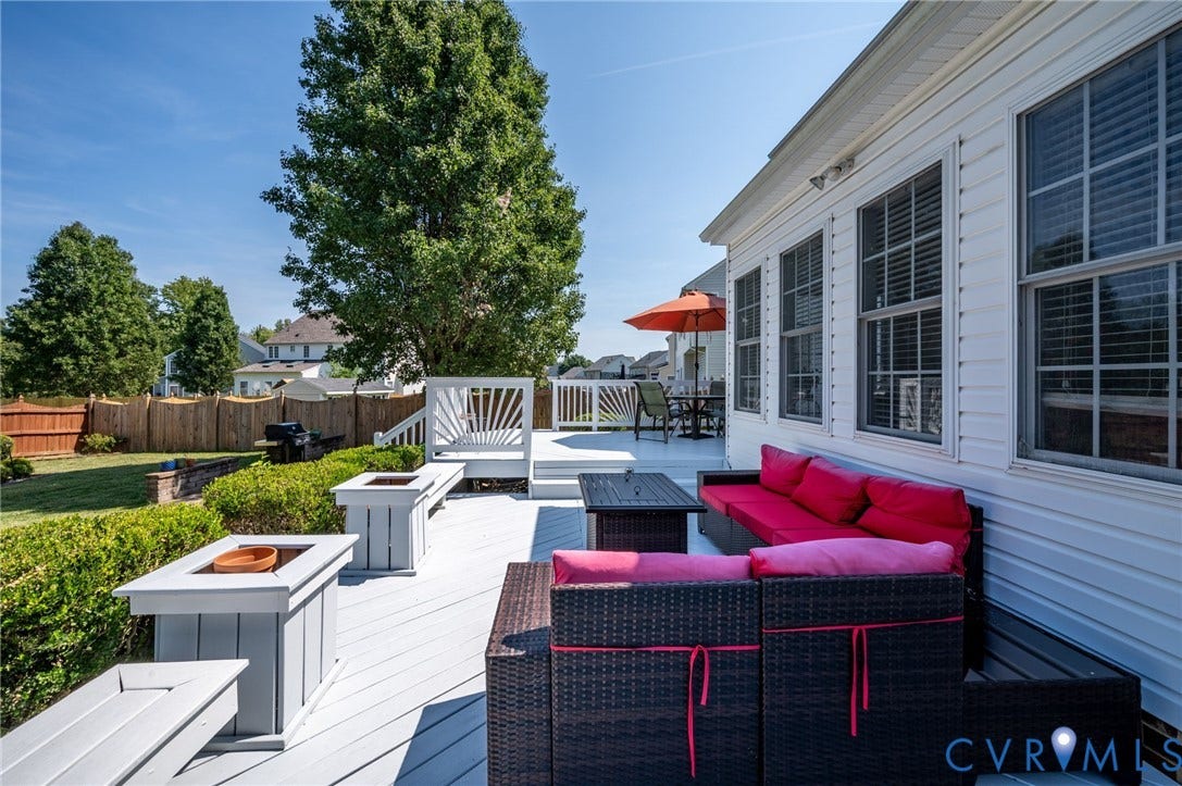 10808 Pruett Lane, Henrico, VA 23059 Expansive composite deck featuring multiple entertaining zones with built-in seating, integrated fire pit, and mature landscaping with privacy hedging