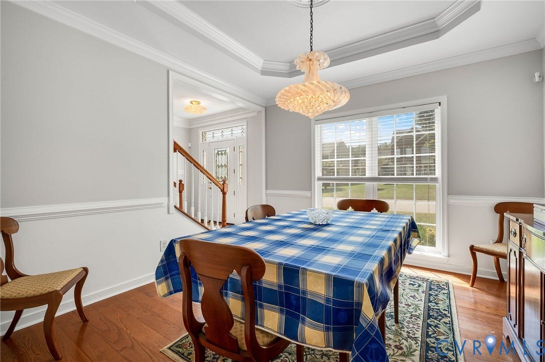 10808 Pruett Lane, Henrico, VA 23059 Tray ceiling, crown molding, chair rail, wood-finish flooring, and a decorative chandelier