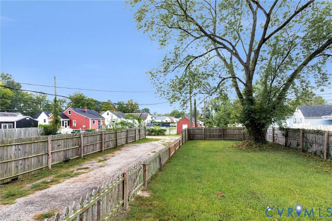 3504 Meadowbridge Road, Richmond, VA 23222 Fenced yard with established tree and gravel driveway