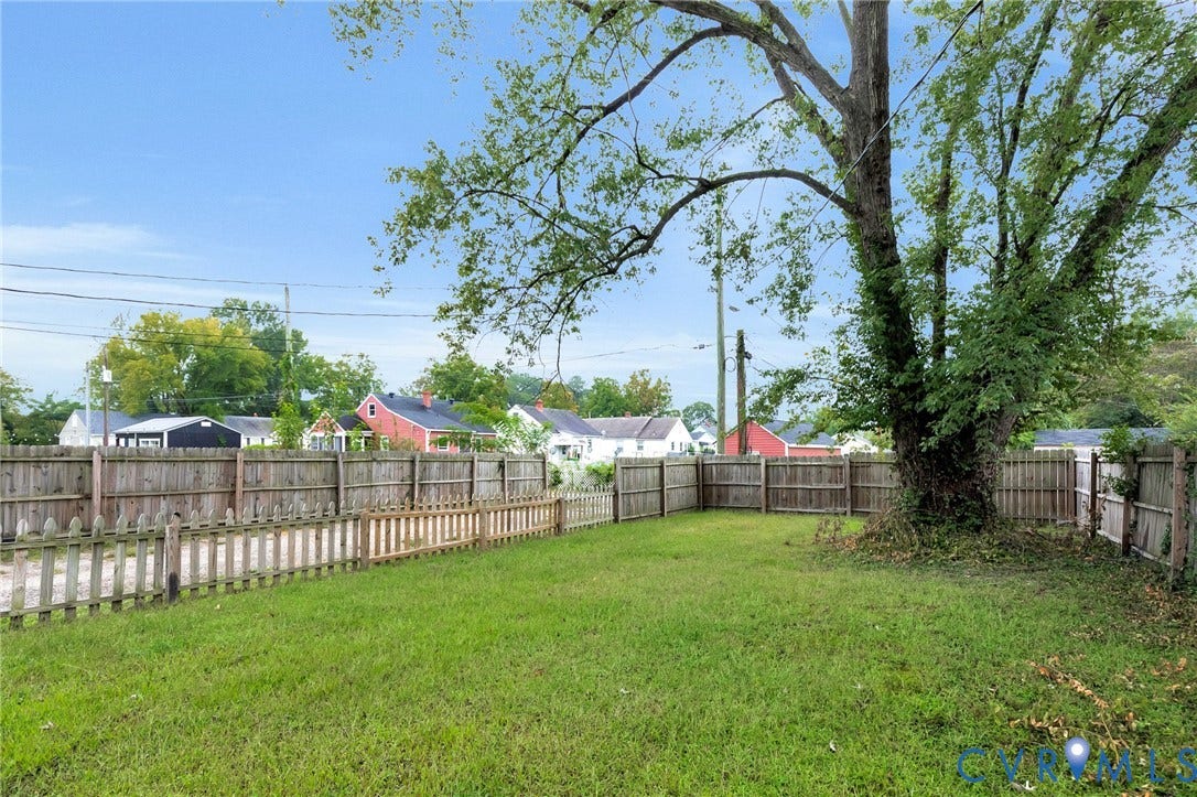 3504 Meadowbridge Road, Richmond, VA 23222 Expansive grassy yard with a privacy fence and a large mature tree