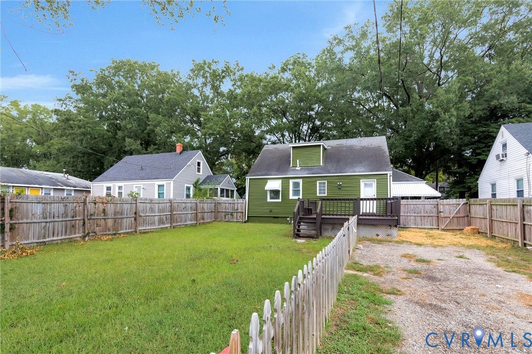 3504 Meadowbridge Road, Richmond, VA 23222 Expansive grassy yard with wood fencing, a private deck, and a gravel driveway