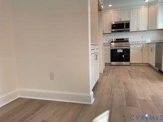 2315 Dee Kay Drive, Henrico, VA 23228 Kitchen featuring white cabinetry, wood-finish flooring, stainless steel appliances, and a light-toned countertop