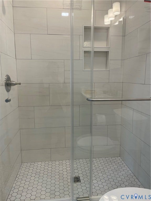 2315 Dee Kay Drive, Henrico, VA 23228 Glass-enclosed shower with white rectangular wall tiling and white hexagonal floor tiling