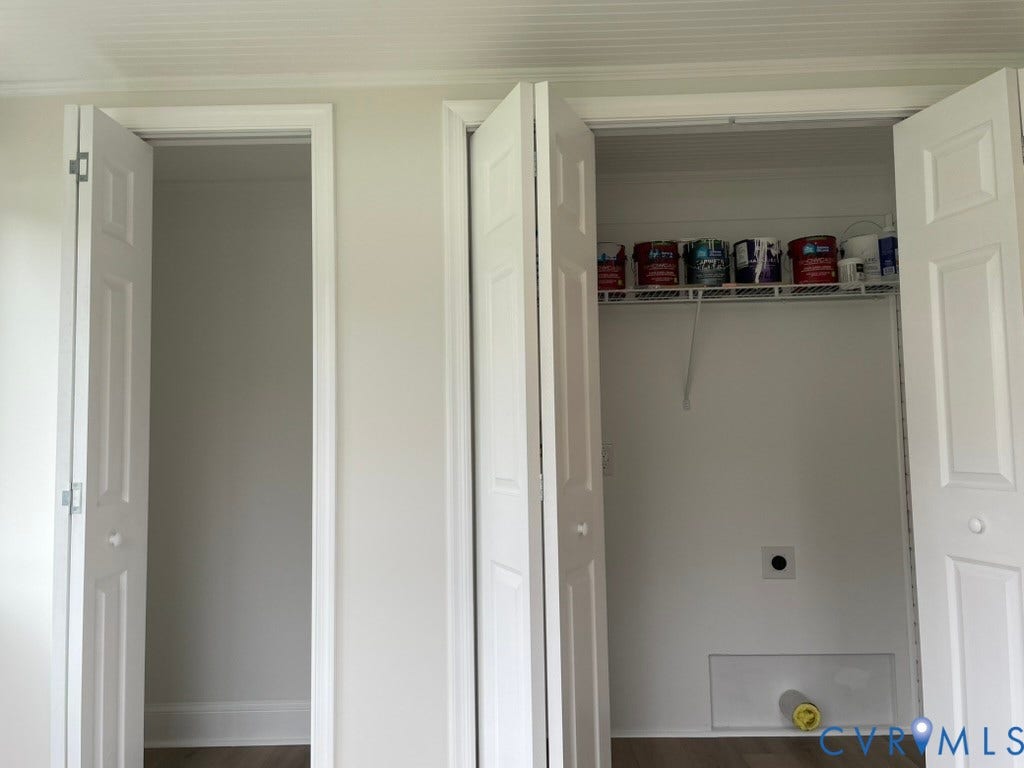 2315 Dee Kay Drive, Henrico, VA 23228 Two white panel doors, one open to a blank closet, the other open to a closet with a wire shelf and a circular opening on the back wall