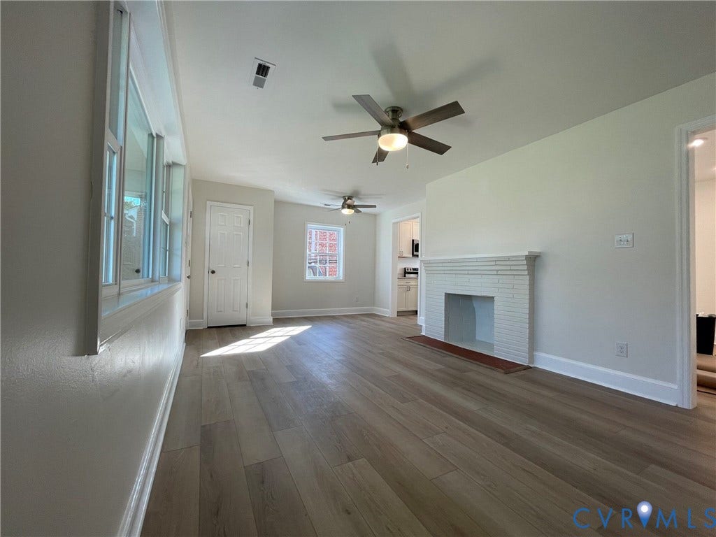 2315 Dee Kay Drive, Henrico, VA 23228 Wood-finish flooring, white brick fireplace, multiple ceiling fans, and natural light from large windows