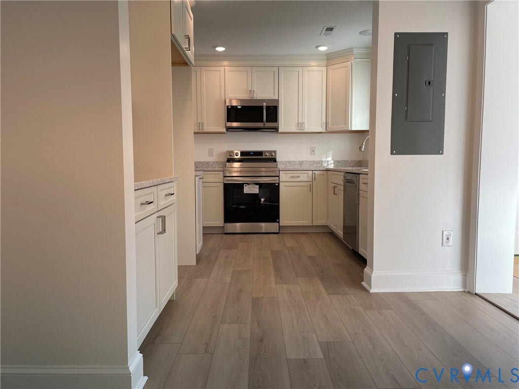 2315 Dee Kay Drive, Henrico, VA 23228 Kitchen featuring white cabinetry, stainless steel appliances, light-toned countertops, and wood-finish flooring