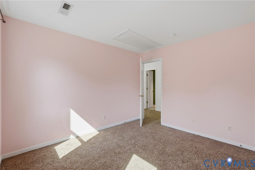 Wall-to-wall carpeting, painted walls, white trim, and a white interior door