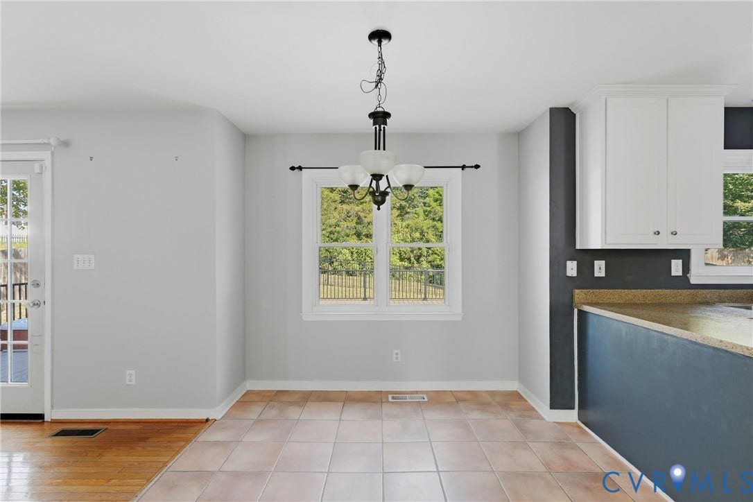 White framed window, tile flooring, wood-finish flooring, white cabinetry, and a built-in countertop