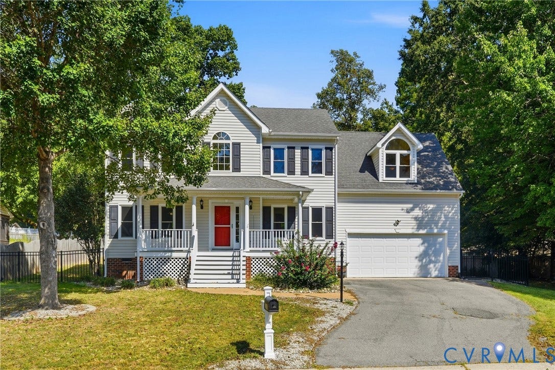 Two-story residence with white siding, a covered front porch, and an attached two-car garage