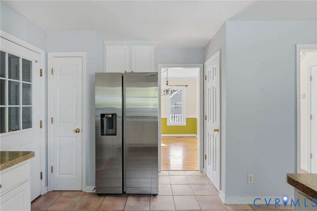 Ceramic tile flooring, white shaker-style cabinetry, and a side-by-side stainless steel refrigerator