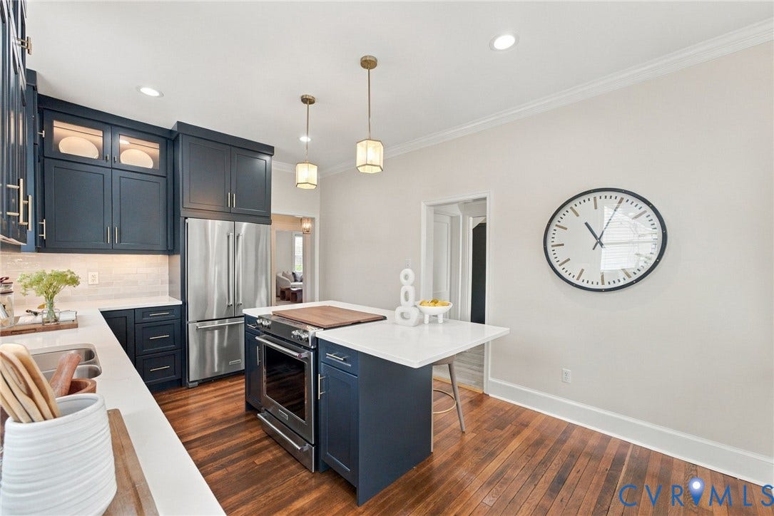 4905 Patterson Avenue, Richmond, VA 23226 Kitchen featuring wood-finish flooring, dark blue cabinetry with gold-toned hardware, light countertops, and stainless steel appliances