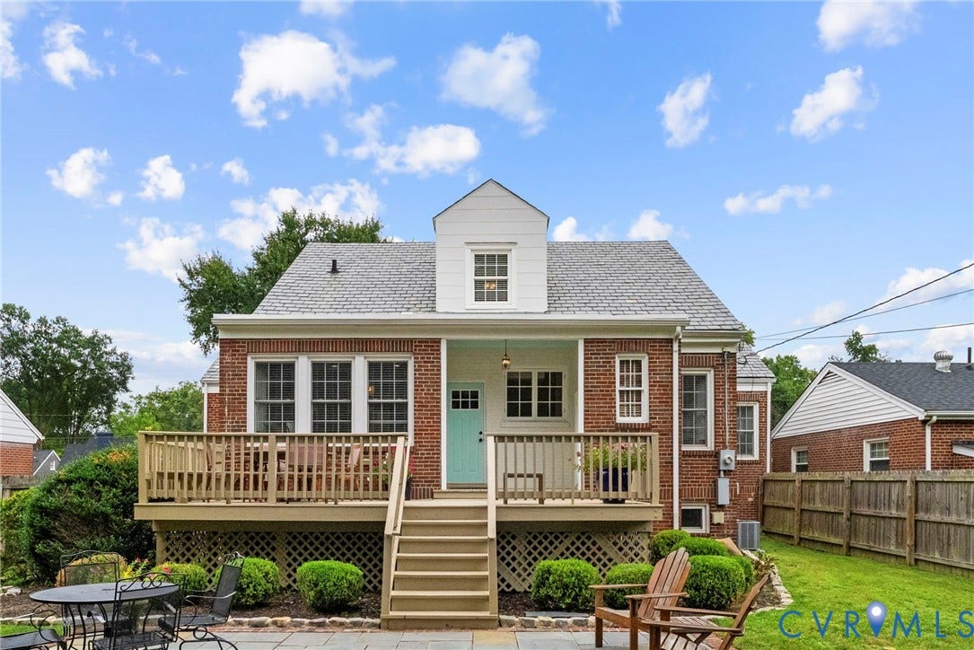 4905 Patterson Avenue, Richmond, VA 23226 Brick exterior with a light blue entry door, wood deck with lattice skirting, and a gabled dormer