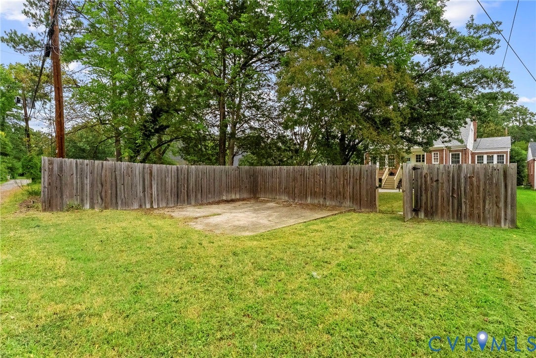 4905 Patterson Avenue, Richmond, VA 23226 Expansive yard space featuring a privacy fence, concrete pad, and mature trees