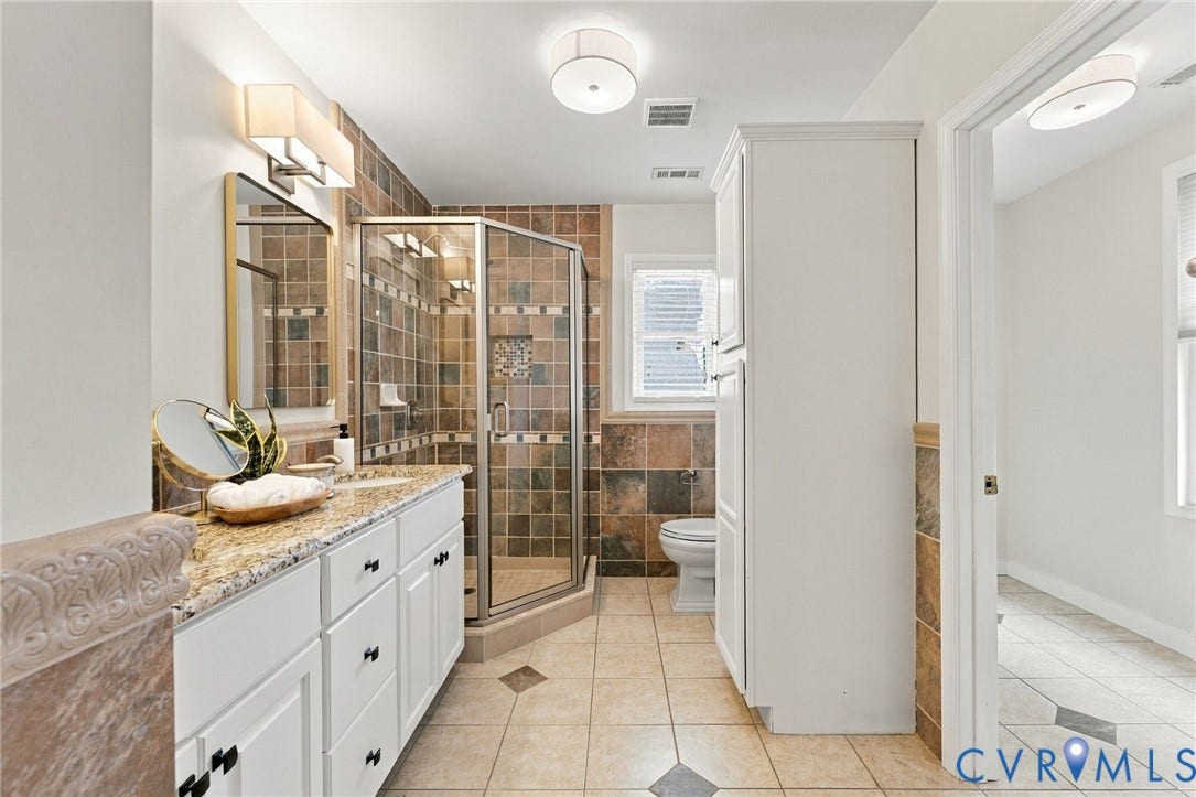 4905 Patterson Avenue, Richmond, VA 23226 Dual-sink vanity with granite countertop, glass-enclosed shower, wall-mounted light fixture, recessed lighting, and tile flooring