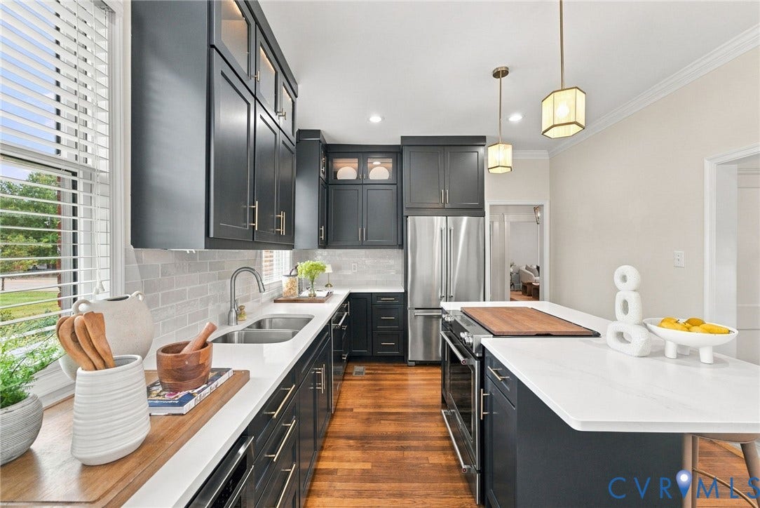 4905 Patterson Avenue, Richmond, VA 23226 Kitchen featuring dark shaker-style cabinetry, stainless steel appliances, a double basin sink, light subway tile backsplash, and light-toned countertops