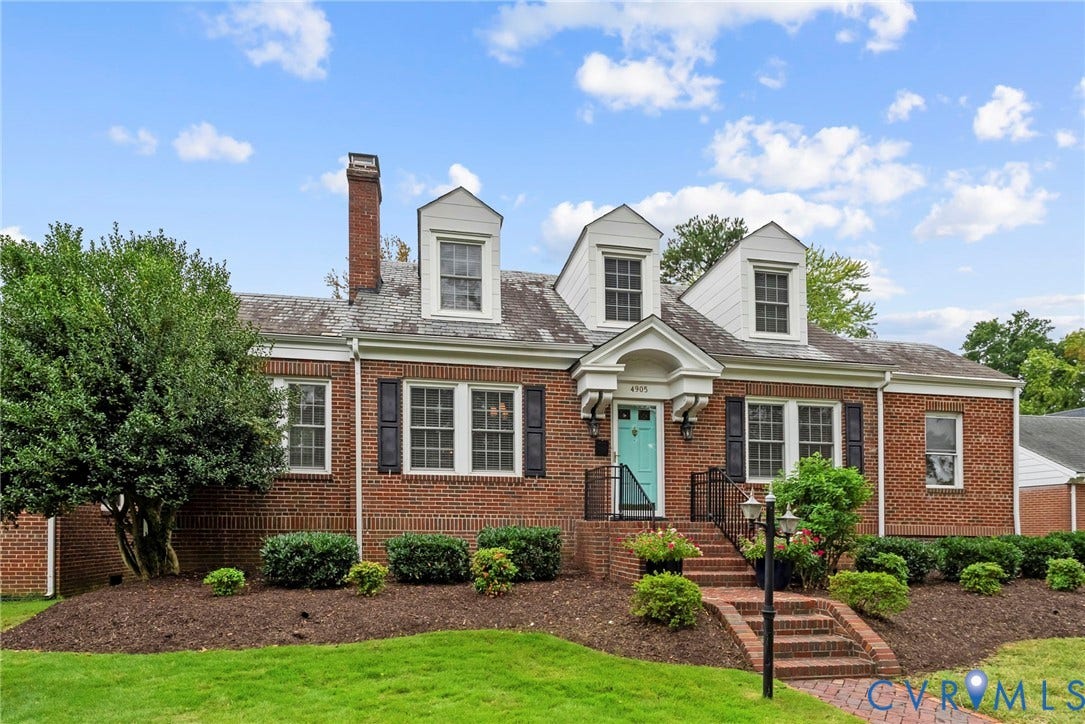 4905 Patterson Avenue, Richmond, VA 23226 Brick exterior with white dormer windows, a bright teal front door, and black window shutters