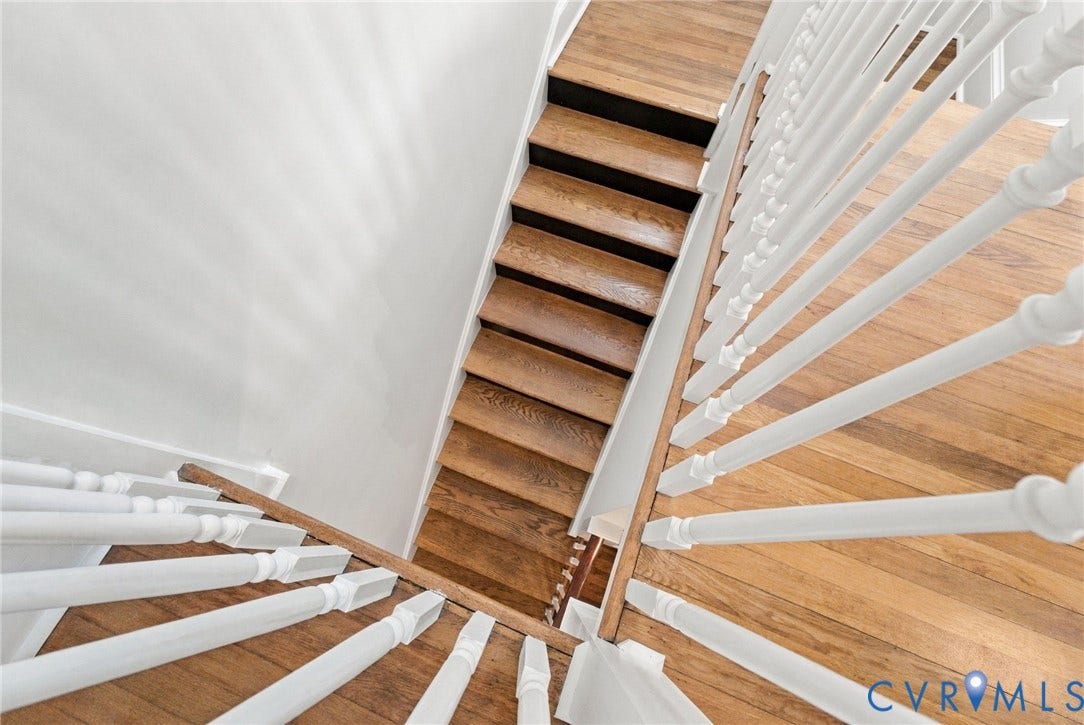 4905 Patterson Avenue, Richmond, VA 23226 Staircase featuring wood-finish treads, risers, and railing with white painted balusters and a white wall