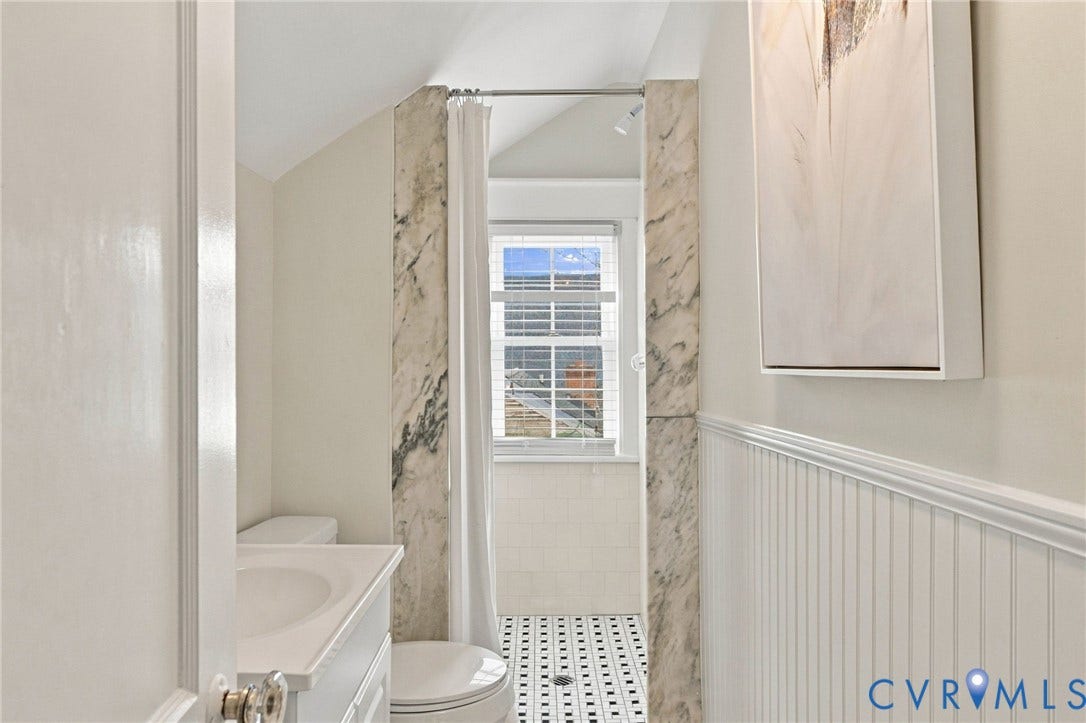 4905 Patterson Avenue, Richmond, VA 23226 White beadboard wall paneling, white vanity with integrated sink, black and white checkered floor tiling, shower with marble-finish wall panels, and an operable window