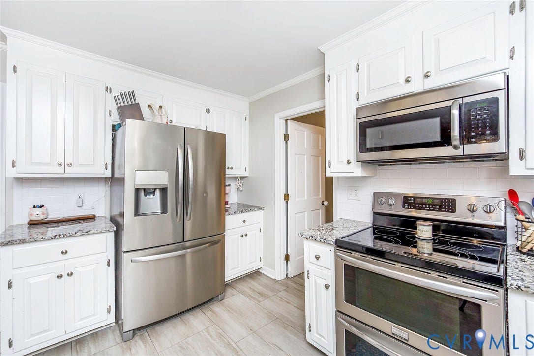 5640 Teterling Court, Lakewood Farms, Chester, VA 23831 White cabinetry with crown molding, stainless steel appliances, granite countertops, subway tile backsplash, and wood-finish flooring