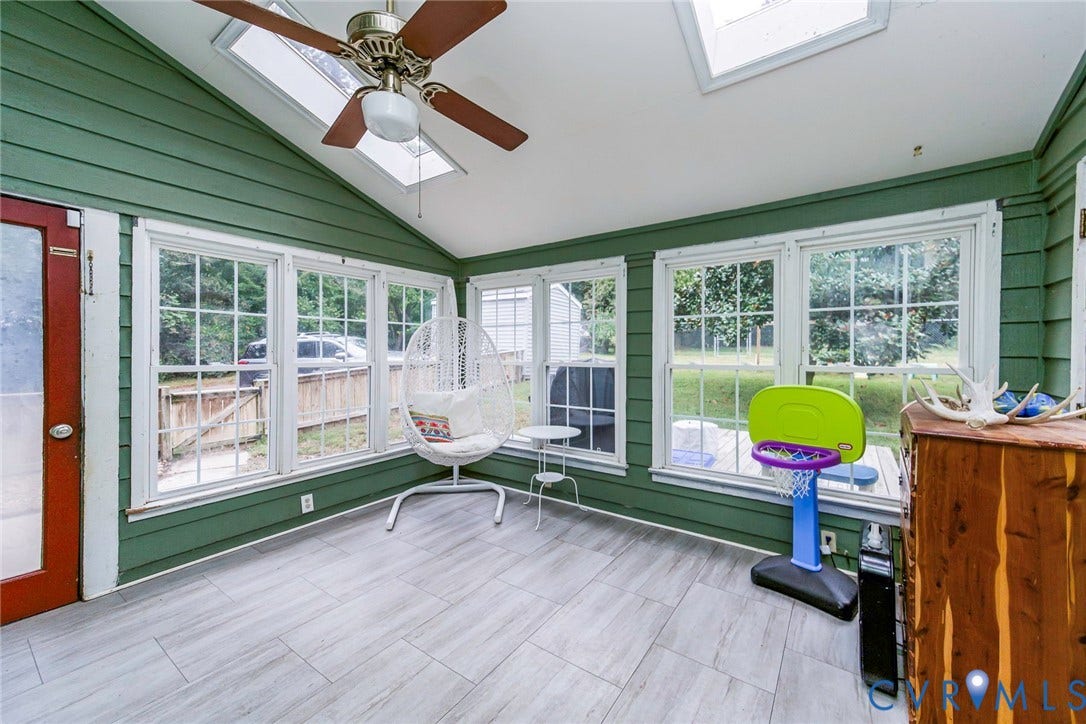 5640 Teterling Court, Lakewood Farms, Chester, VA 23831 Vaulted ceiling sunroom featuring multiple windows, skylights, a ceiling fan, and wood-finish flooring