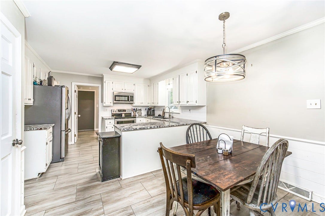 5640 Teterling Court, Lakewood Farms, Chester, VA 23831 White cabinetry, granite countertops, stainless steel appliances, wood-finish tile flooring, and a decorative pendant light fixture