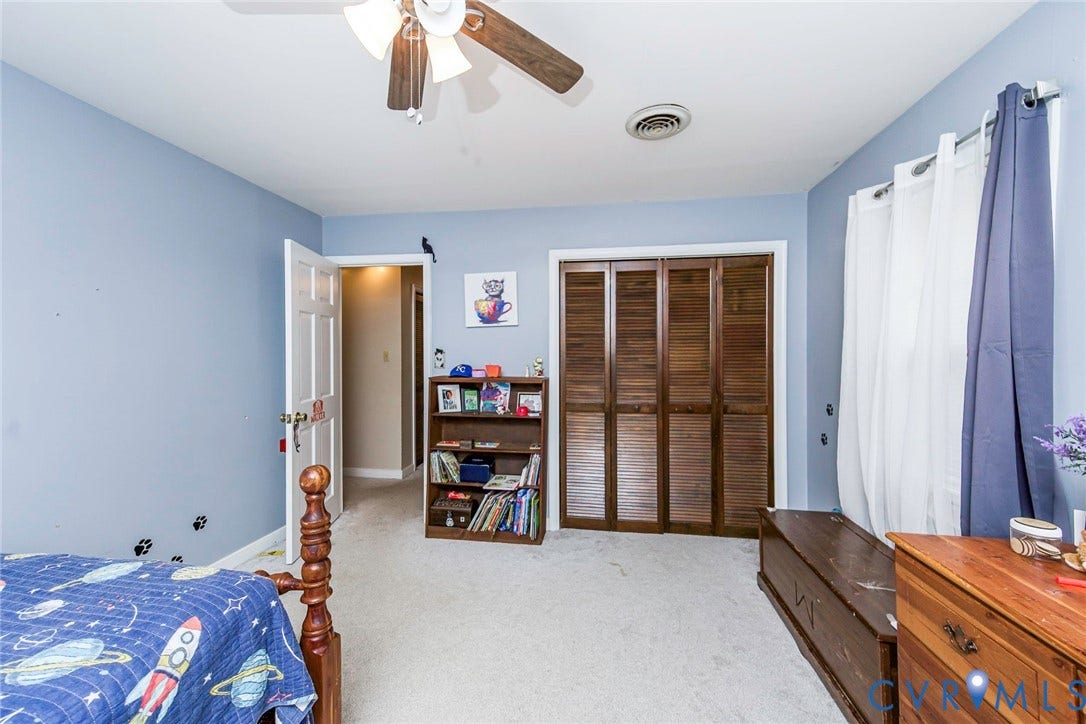 5640 Teterling Court, Lakewood Farms, Chester, VA 23831 Carpeted room featuring a ceiling fan, a white paneled door, and louvered bi-fold closet doors