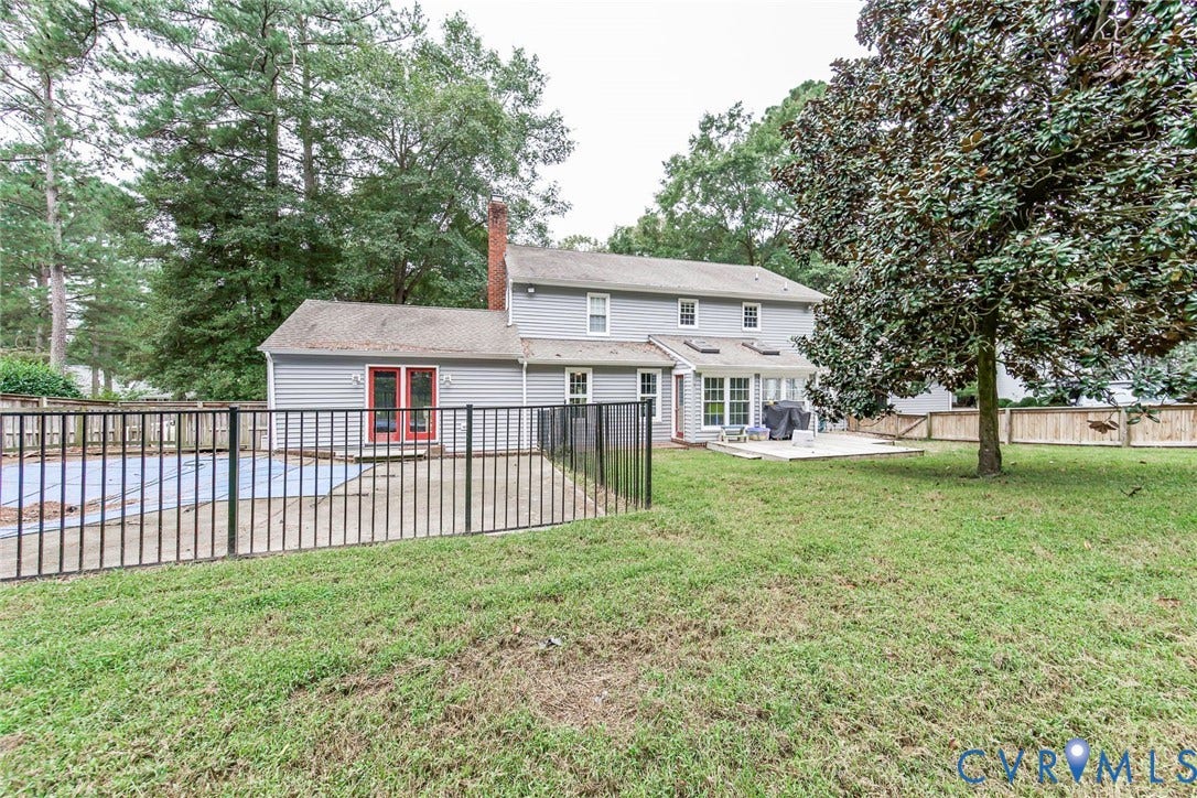 5640 Teterling Court, Lakewood Farms, Chester, VA 23831 Expansive rear yard featuring a concrete patio, mature trees, and a fenced-in pool area with a covered pool