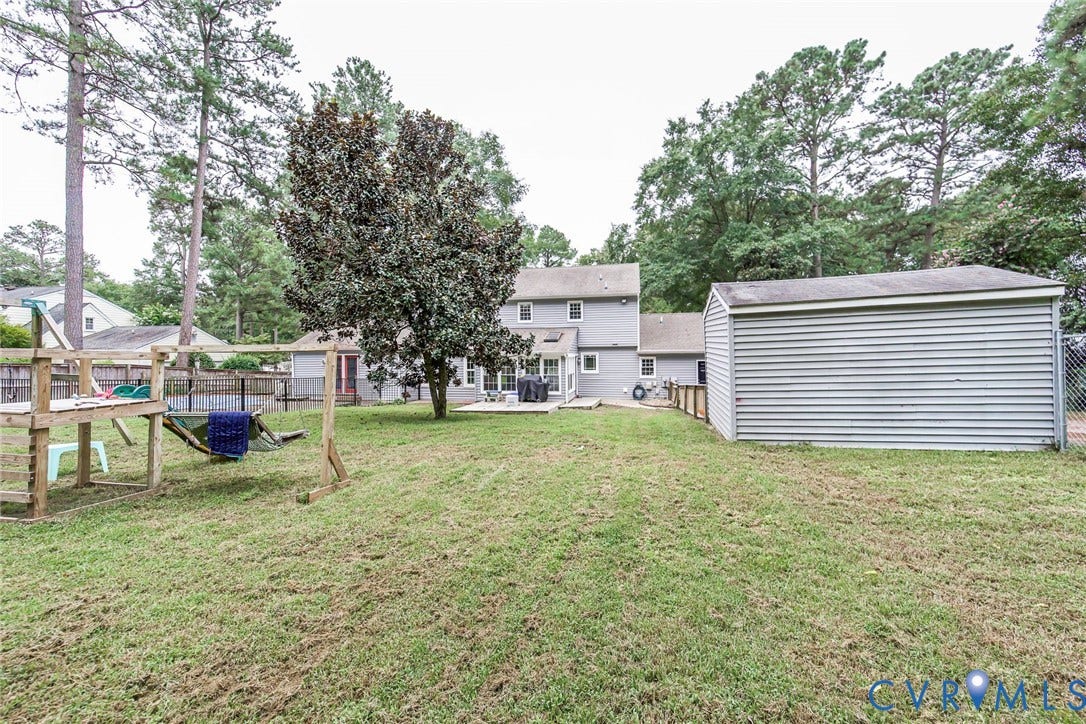 5640 Teterling Court, Lakewood Farms, Chester, VA 23831 Expansive grassy yard featuring mature trees, a multi-level deck, and a detached storage shed with horizontal siding