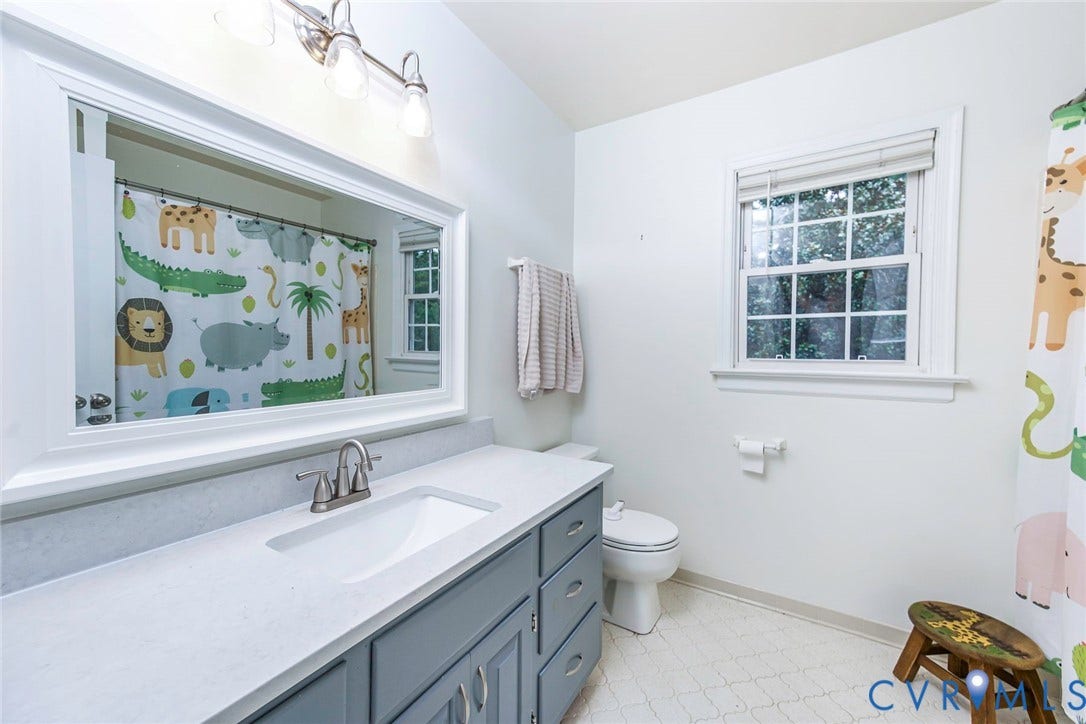 5640 Teterling Court, Lakewood Farms, Chester, VA 23831 White vanity with an integrated sink, brushed nickel faucet, large framed mirror, and a window for natural illumination
