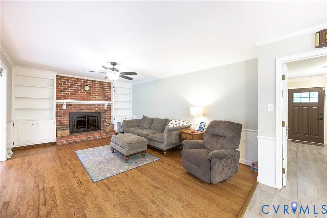 5640 Teterling Court, Lakewood Farms, Chester, VA 23831 Living area with hardwood flooring, brick fireplace surround, built-in shelving, and crown molding