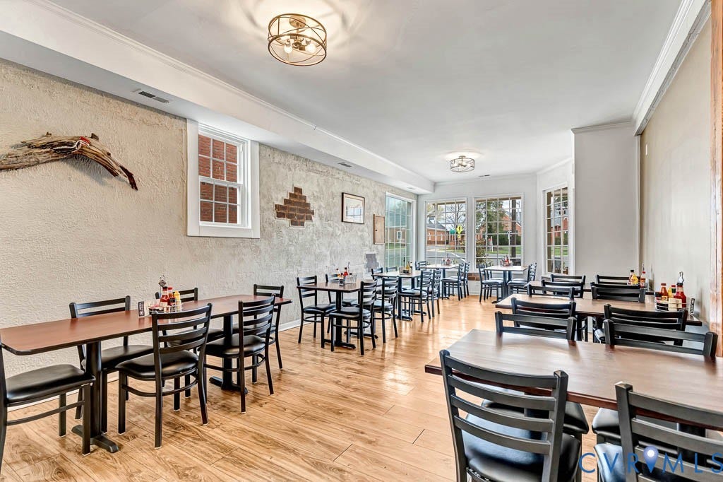 Spacious interior with wood-finish flooring and multiple windows providing natural illumination